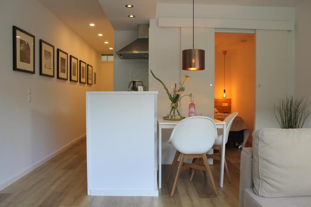 een eetkamer met een tafel en een witte stoel bij Appartement HideAway Nr 17 - Amelander Kaap in Hollum