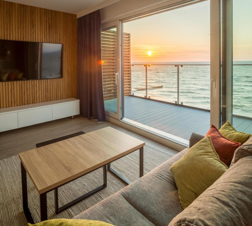 a living room with a couch and a view of the ocean at Apartos Sailor - Luxury Apartments in Ustronie Morskie