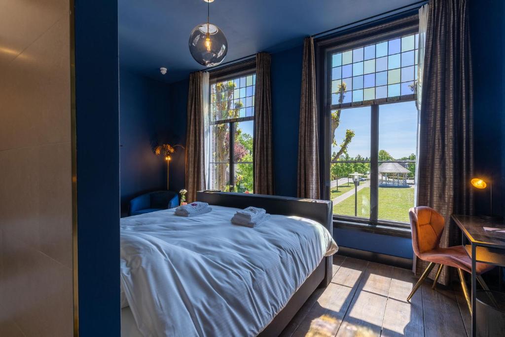 1 dormitorio azul con 1 cama y 2 ventanas en Boutique hotel Lytel Blue, en Riethoven