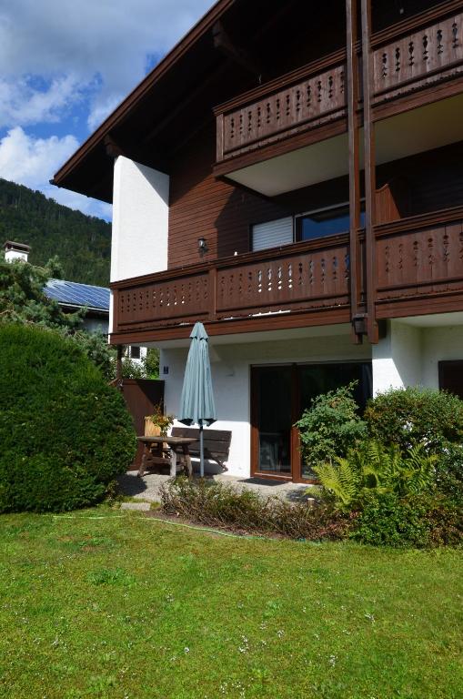 a house with a patio with an umbrella in the yard at Apartment Moore in Reit im Winkl