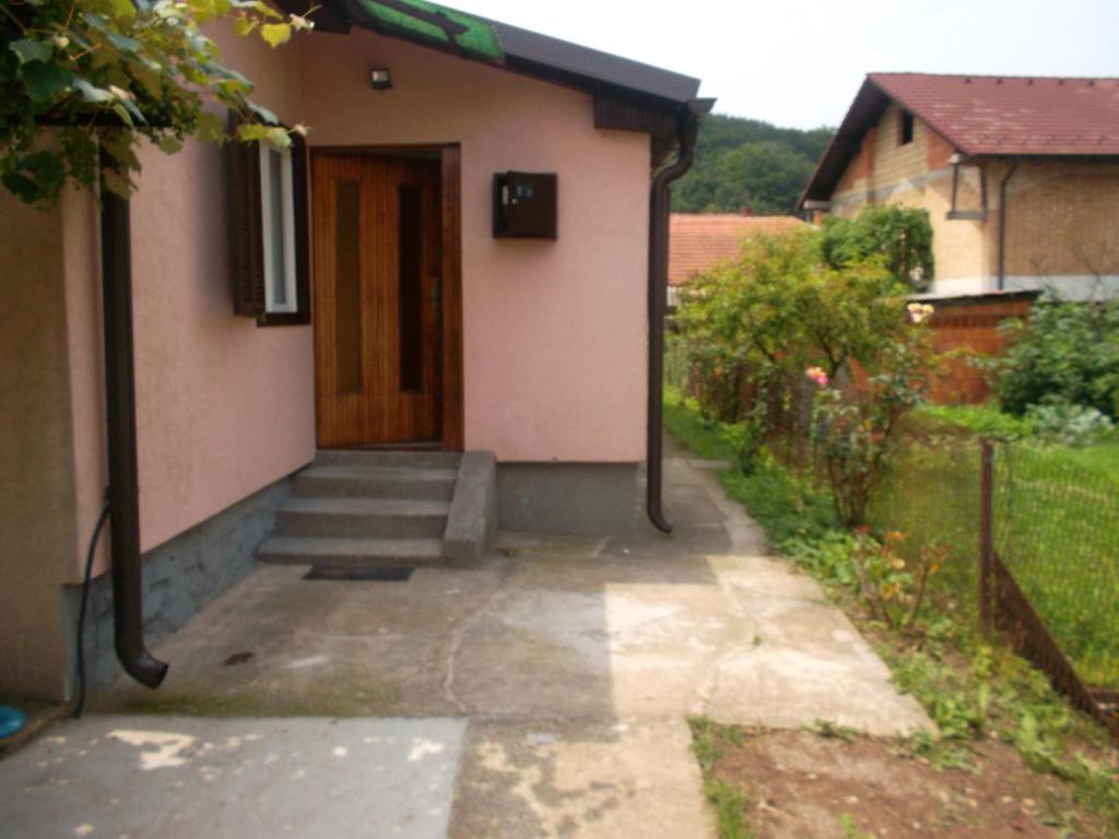 une maison avec une porte et des escaliers dans une cour dans l'établissement Apartman Magdalena, à Banja Koviljača