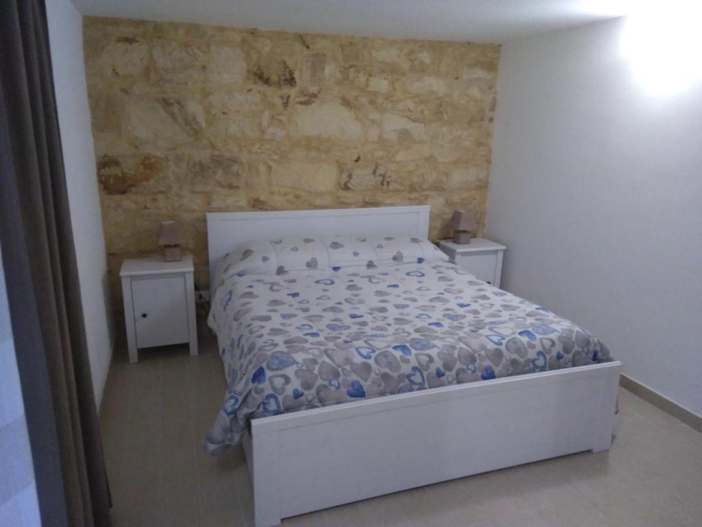 een slaapkamer met een bed en twee nachtkastjes bij La Casetta a Ragusa in Ragusa