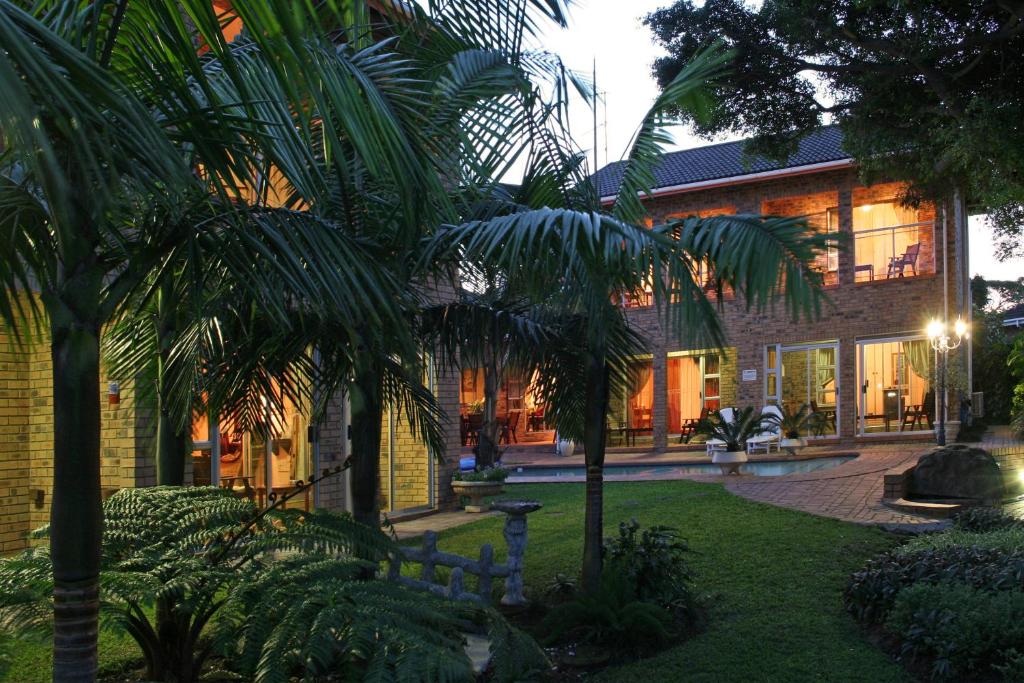 une maison avec des palmiers devant elle dans l'établissement DuneSide Guest House, à Richards Bay