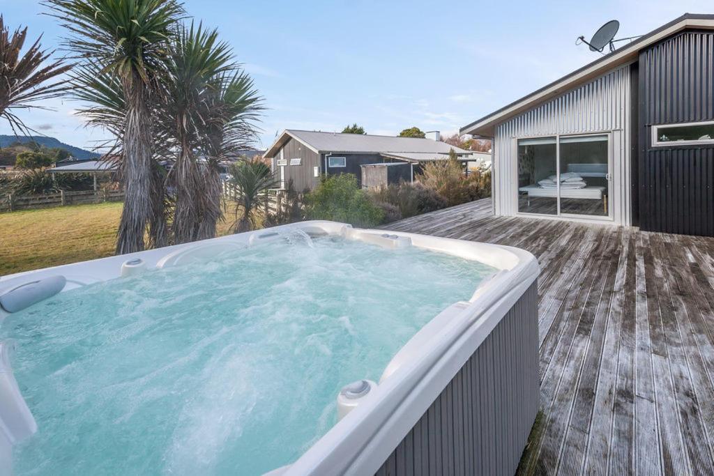 a hot tub on the deck of a house at Les Fleurs avec Spa - Ohakune Holiday Home in Ohakune