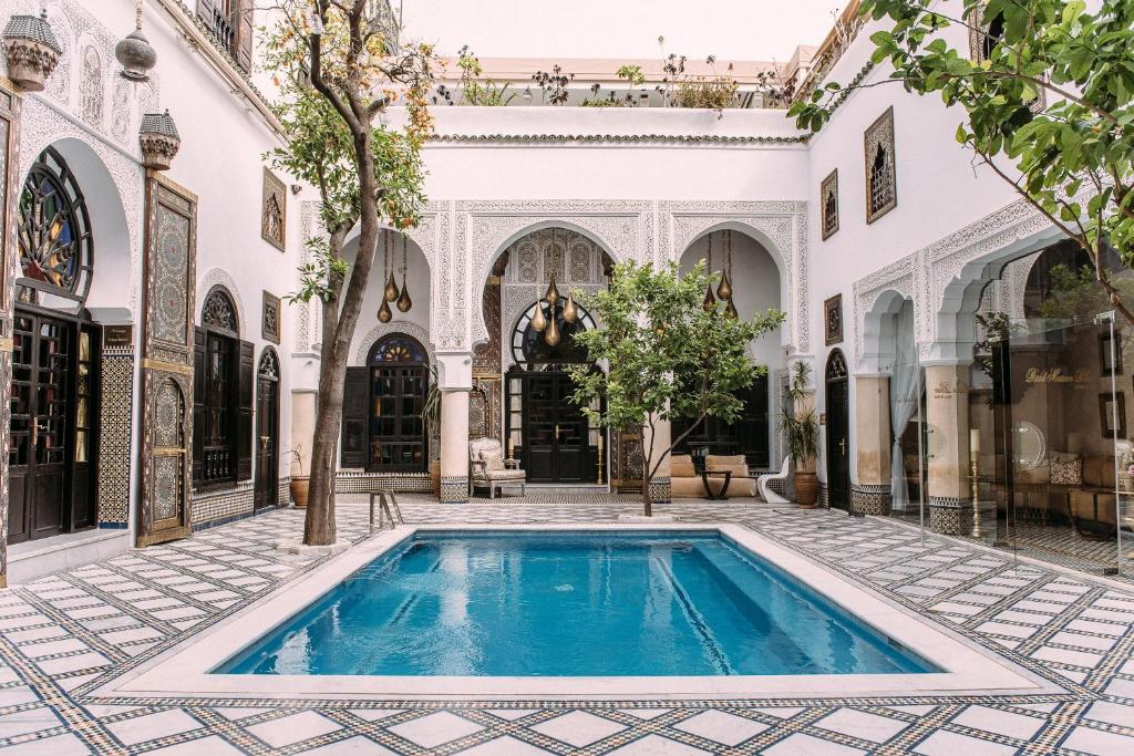 a courtyard with a swimming pool in a building at Riad Maison Bleue and Spa in Fès