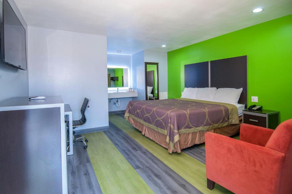 a hotel room with a bed and a green wall at Executive Inn Fort Stockton in Fort Stockton