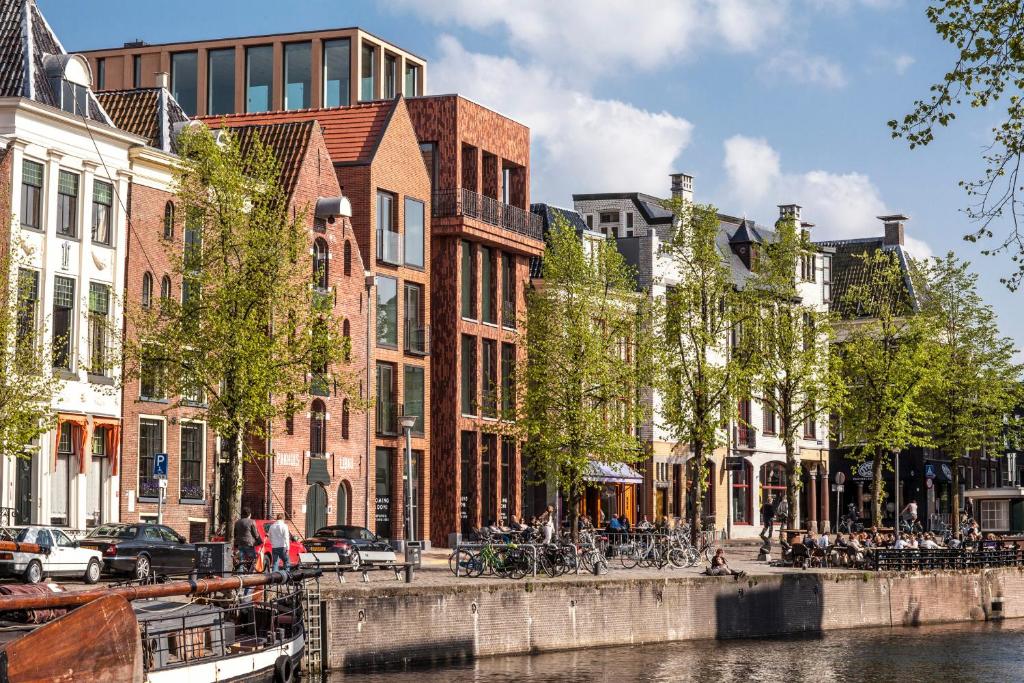 a city street with buildings and a canal with bikes at Hotel Miss Blanche in Groningen