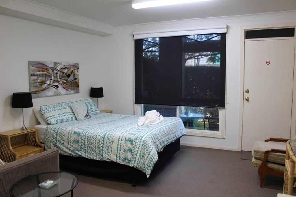 a bedroom with a bed and a large window at Box Hill Studio 3 at Canterbury Gardens in Box Hill