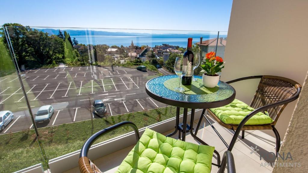 a balcony with a table and chairs and a view of a street at Rona Studio Apartment Tena in Lovran