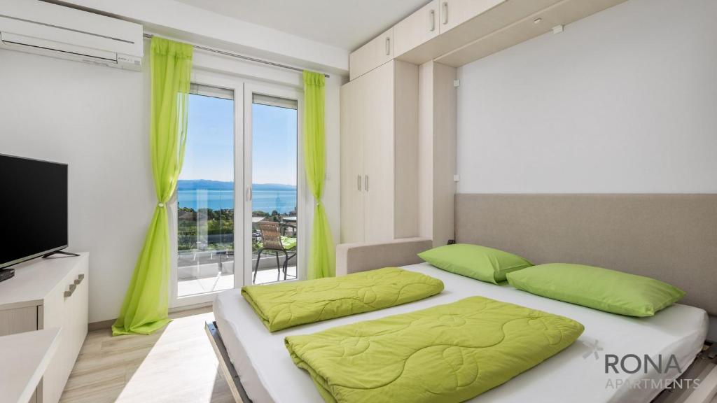 een slaapkamer met 2 bedden en een groot raam bij Rona Studio Apartment Tena in Lovran