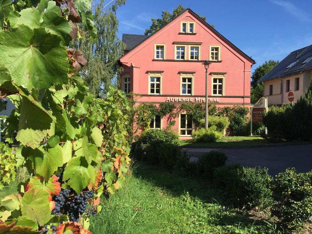 una casa con un grappolo d'uva davanti di Wein-Hotel Auberge Mistral a Freiberg