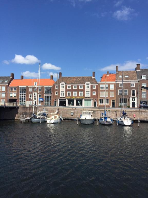 um grupo de barcos ancorados num porto com edifícios em Sol Aureus em Middelburg