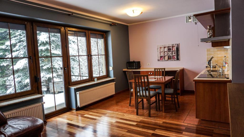 uma cozinha e sala de jantar com mesa e cadeiras em MSC Apartments Zaciszny Kącik em Zakopane