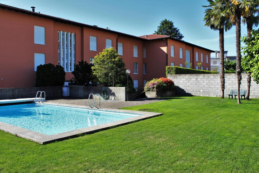 a swimming pool in a yard next to a building at Residenza al Mulin in Ascona