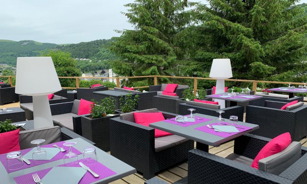 a restaurant with purple and pink tables and chairs at Hotel Le Panorama in Le Mont-Dore
