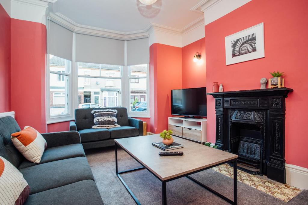 a living room with red walls and a fireplace at Beautifully Finished Spacious House! in Rugby
