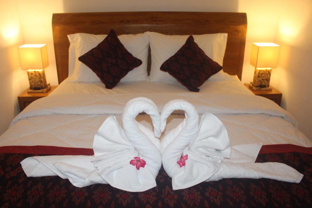 - deux serviettes de cygne au-dessus d'un lit dans l'établissement Intan Guest House, à Ubud