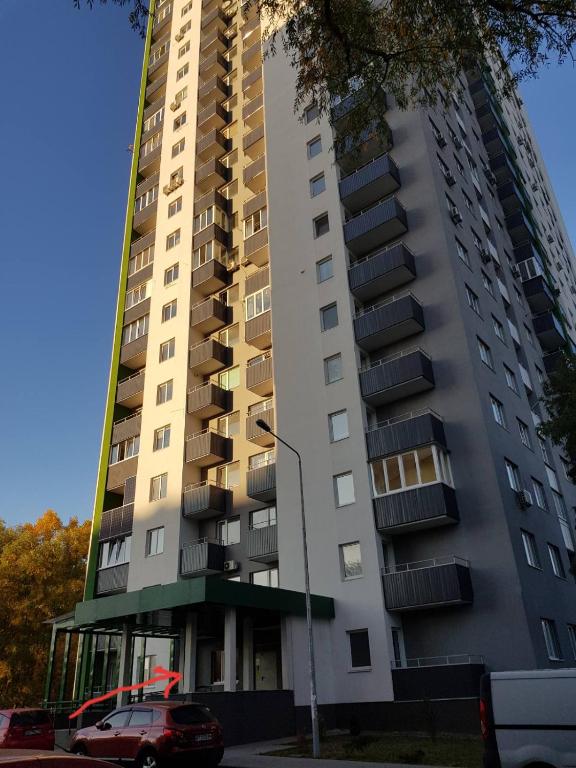a tall building with a car parked in front of it at Теремки in Kyiv