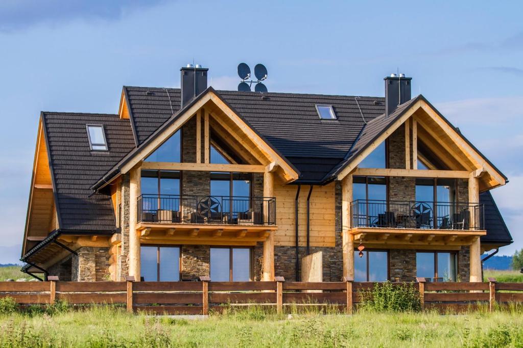 a log home with a black roof at udanypobyt Apartamenty Czorsztyn in Kluszkowce