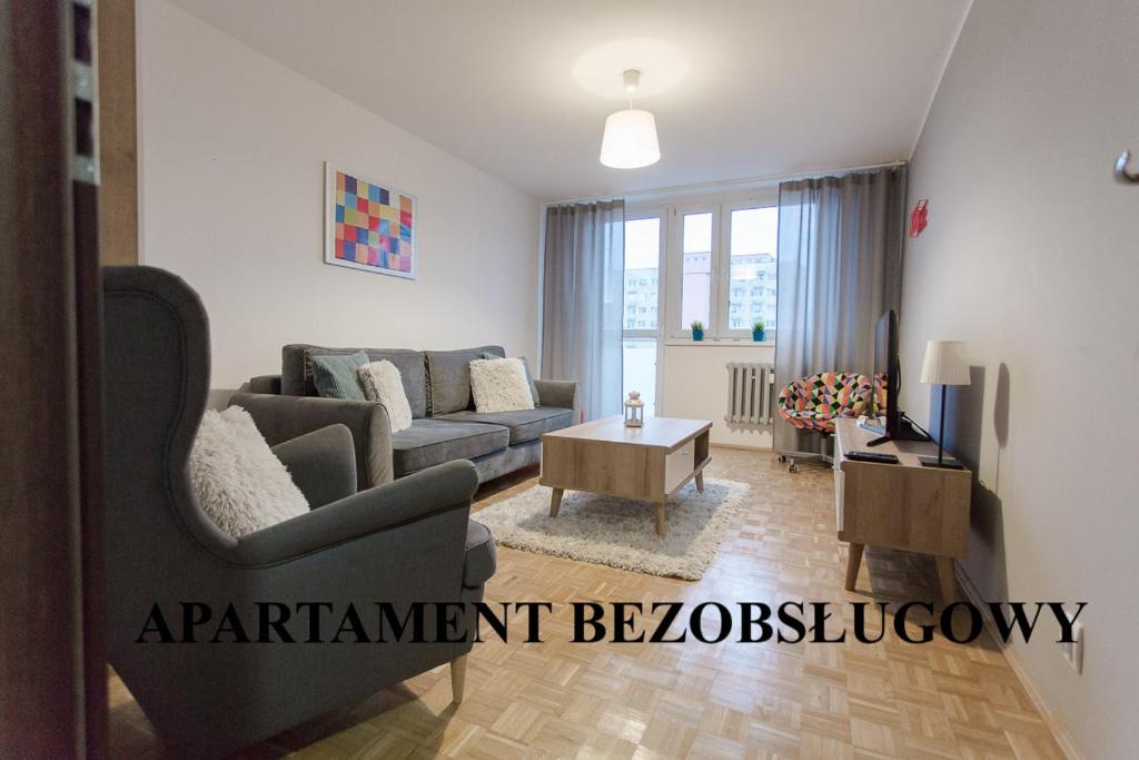een woonkamer met een bank en een tafel bij Nest Arena Toruń in Toruń