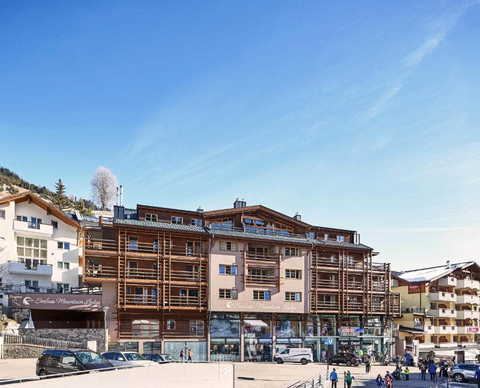 ein großes Gebäude mit Leuten, die davor laufen in der Unterkunft Serfaus Mountain Lodge in Serfaus