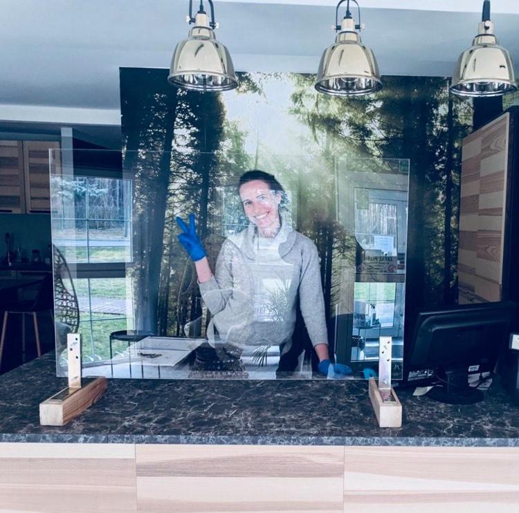 a picture of a woman standing behind a counter at Hotel Szablewski in Dymaczewo Nowe