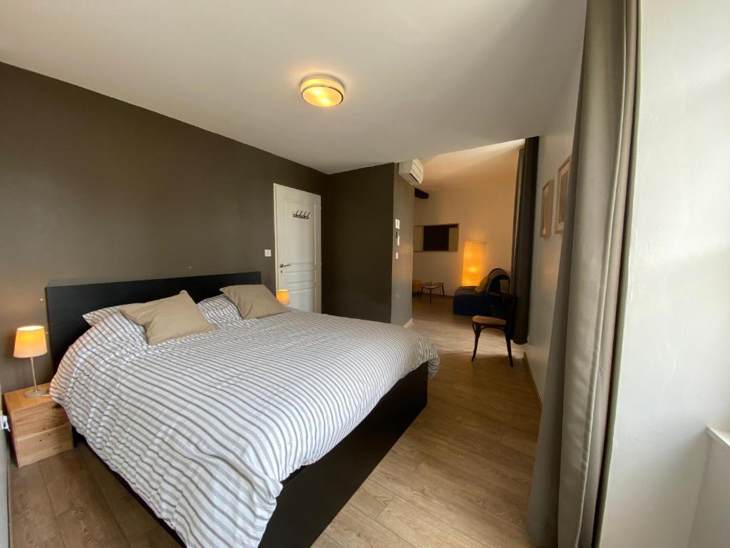 a bedroom with a large bed with a striped blanket at Logis des Jurats in Saint-Émilion