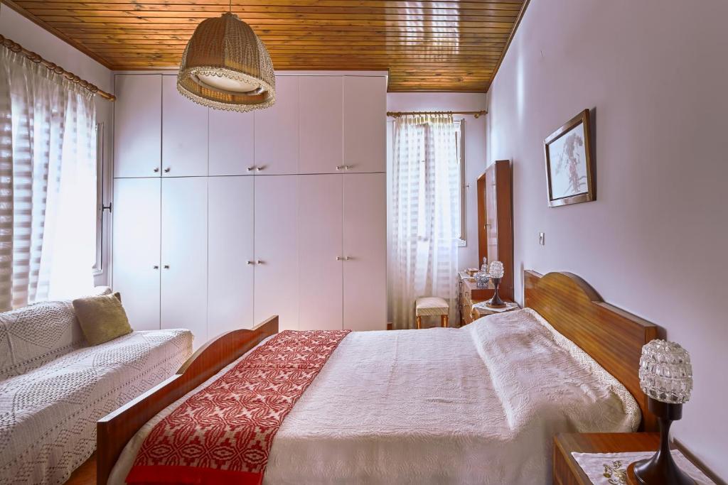 1 dormitorio con 1 cama grande y 1 sofá en Villa Manthos, en Avdhellás