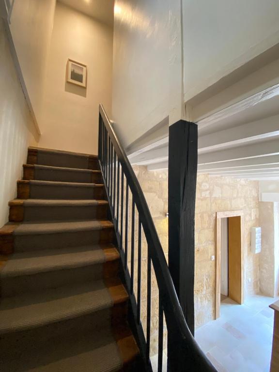 a staircase in a house with a stone wall at Logis des Jurats in Saint-Émilion