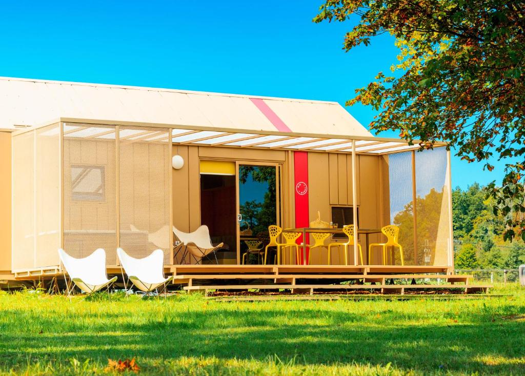 een stacaravan met stoelen en een tafel in een veld bij BIG BERRY Luxury Lifestyle Resort in Metlika