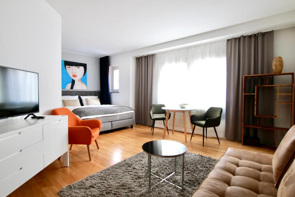 a bedroom with a bed and a living room at Arthouse Apartments im Belgischen Viertel in Cologne