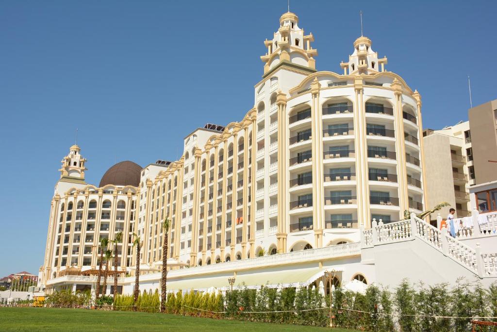 a large white building with a fence in front of it at J'adore Deluxe Hotel & Spa Ultra All Inclusive in Side