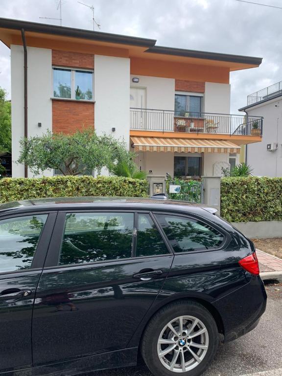 une voiture noire garée devant une maison dans l'établissement Cepele House, à Lignano Sabbiadoro