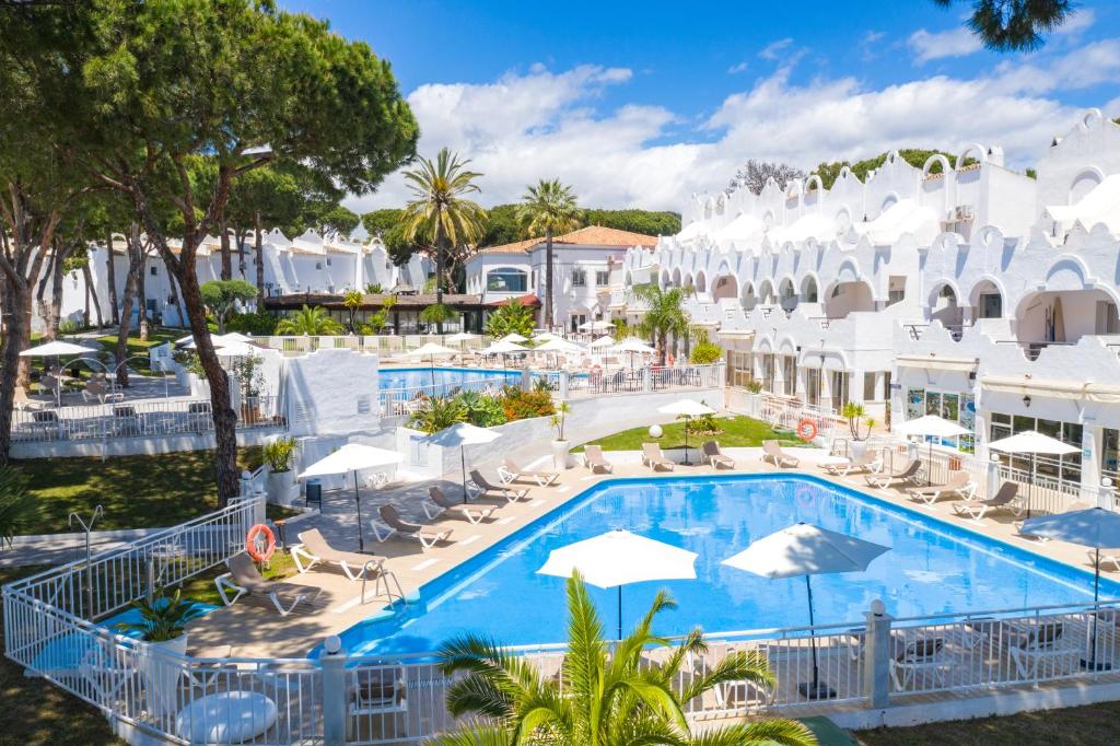 a beach with a pool, chairs, and a pool table at VIME La Reserva de Marbella in Marbella