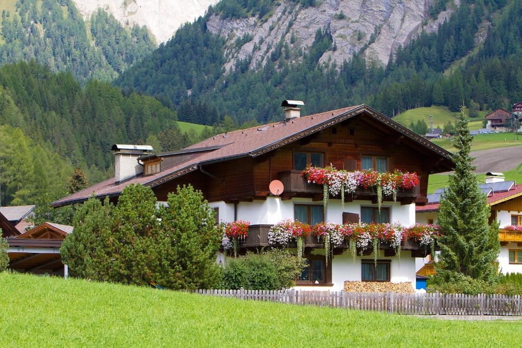 una casa con cajas de flores a un lado. en Ferienhaus Aurora, en Kals am Großglockner