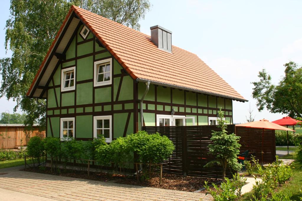 uma casa verde com um telhado laranja em Ferienhaus Seegasse 4 em Göhren-Lebbin