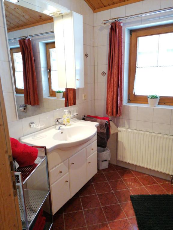 a bathroom with a sink and a tub and a toilet at Apartments Scherer in Obertilliach