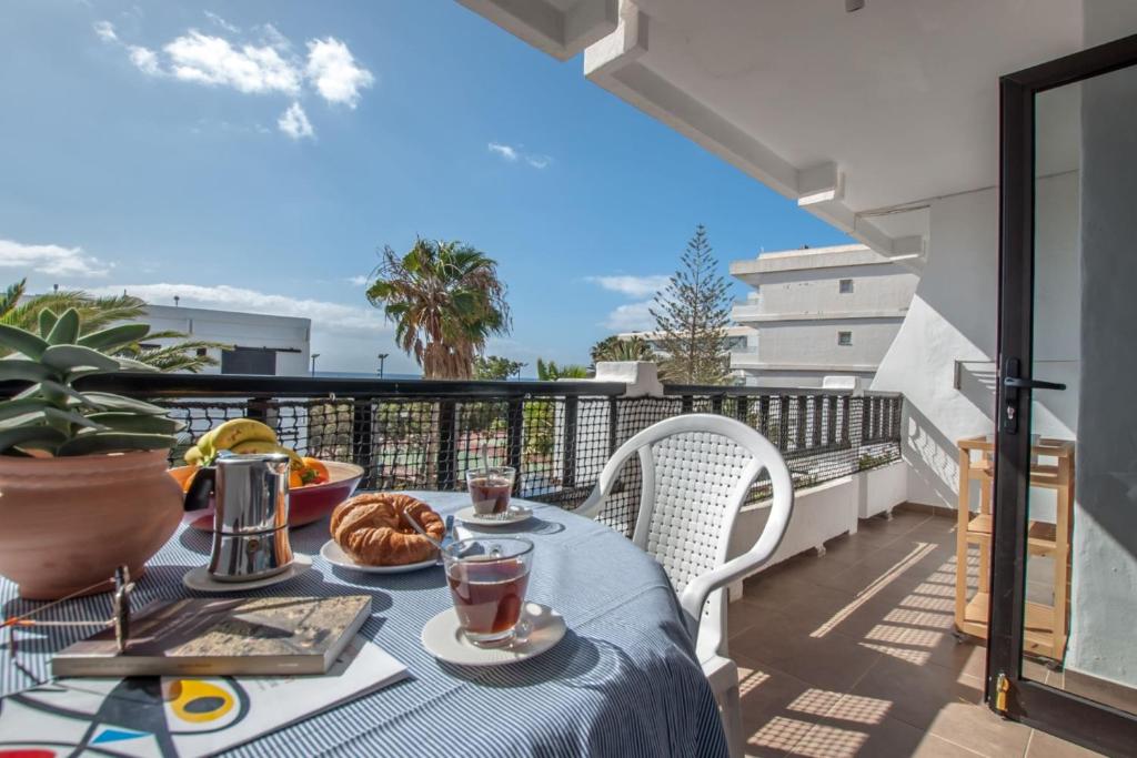 una mesa en un balcón con una comida en Casa Coral with sea views & AC, en Puerto del Carmen