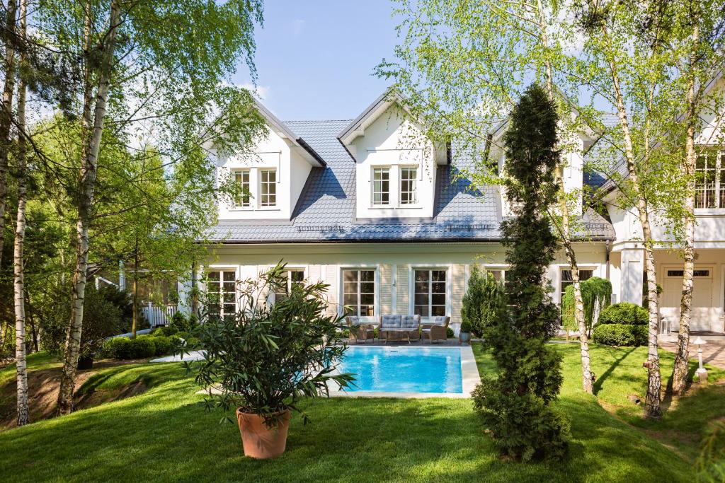 une maison avec une piscine dans la cour dans l'établissement Dwór Złotopolska Dolina Mansion House, à Trębki