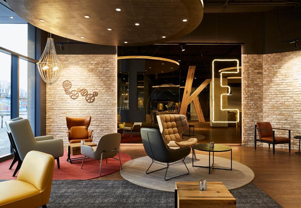 a lobby with chairs and a large letter k on the wall at Hotel Indigo Berlin - East Side Gallery in Berlin