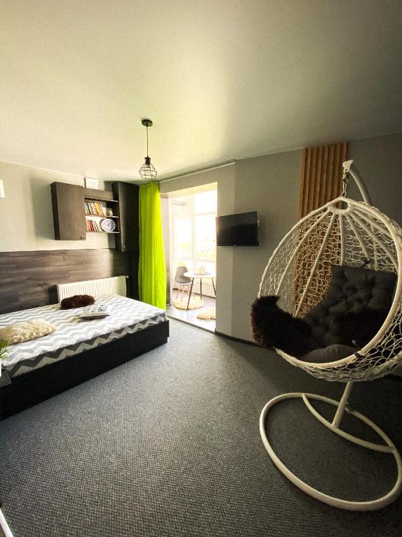 a bedroom with a bed and a hanging swing at Belvederska apartment 3 in Ivano-Frankivsʼk