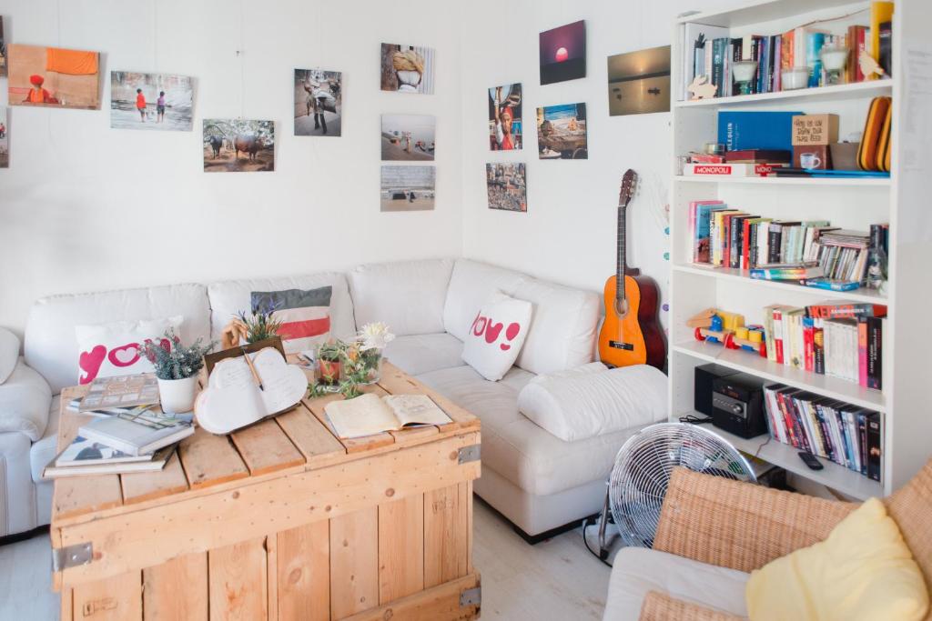 a living room with a white couch and a guitar at Hostal Vidamia in Málaga