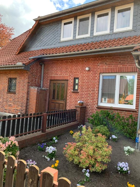 ein Haus mit einem Zaun und Blumen im Vorgarten in der Unterkunft Ferienwohnung Duensing in Neudorf