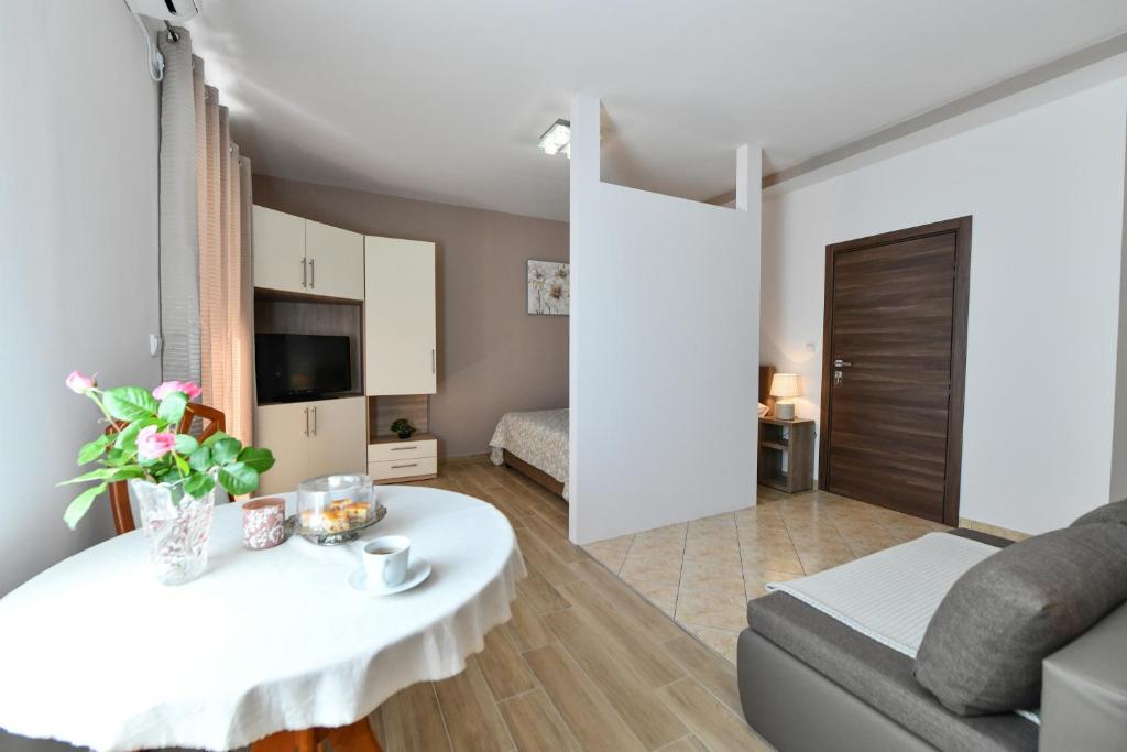 a living room with a white table and a couch at Apartments Vila Miranda in Vodice