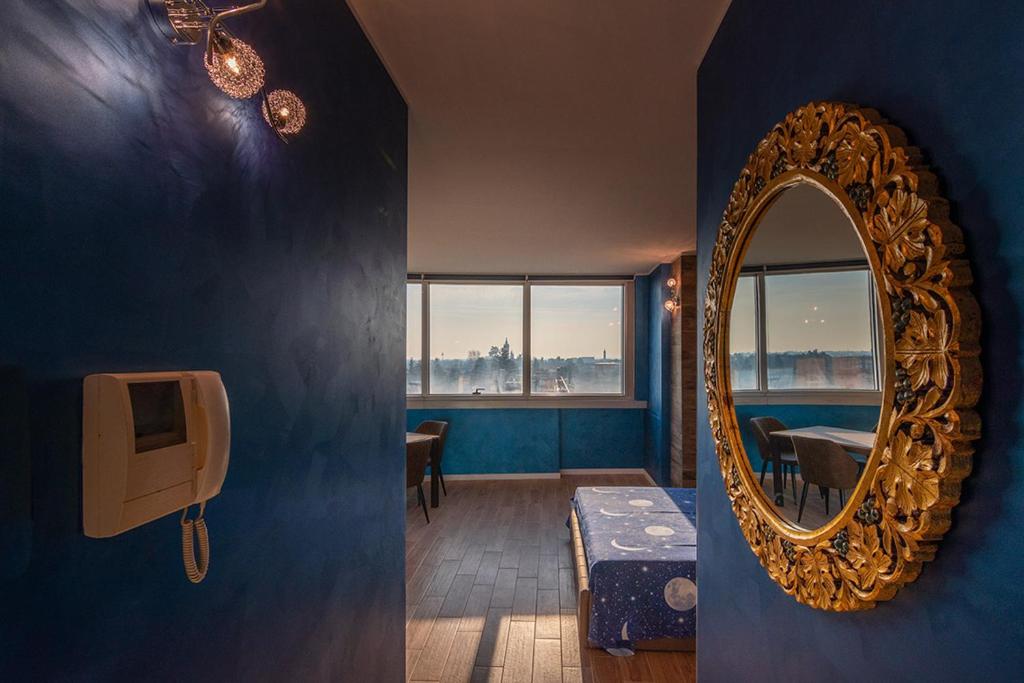 espejo en una habitación azul con mesa y sidra de mesa en Crystal Tower M&M en Treviolo