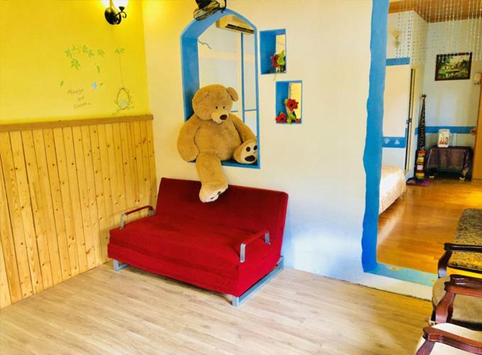 a teddy bear sitting on top of a red stool at 築夢咖啡民宿 in Hsinchu City