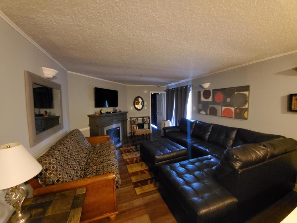 a living room with black leather furniture and a fireplace at Winterplace Condos - Ski In Ski Out! E101 in Ghent