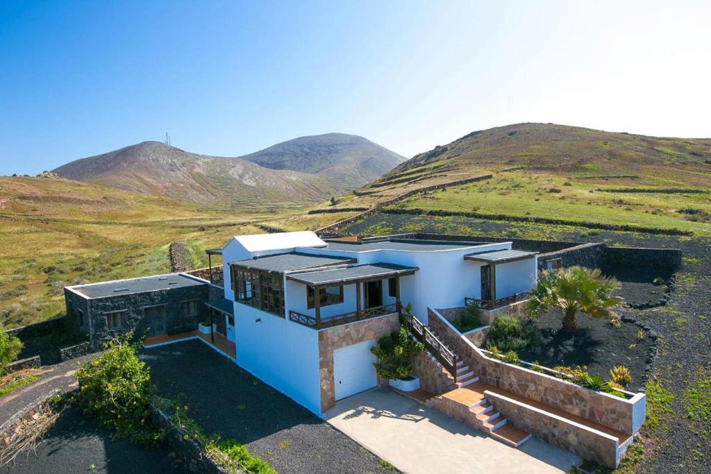 a house in a field with mountains in the background at CASA ACEQUIA in Tinajo