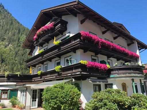 a building with flowers on the side of it at Apart Matthias in Mayrhofen