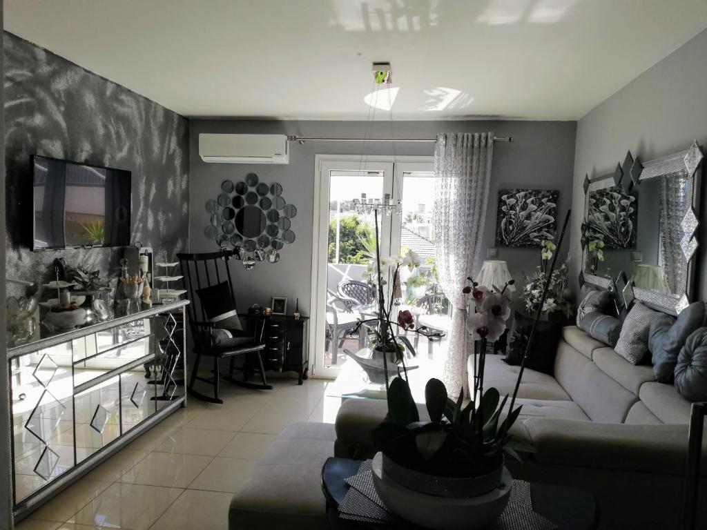 ein Wohnzimmer mit einem Sofa und einem TV in der Unterkunft Diamond City Lux Apartment in Argostoli